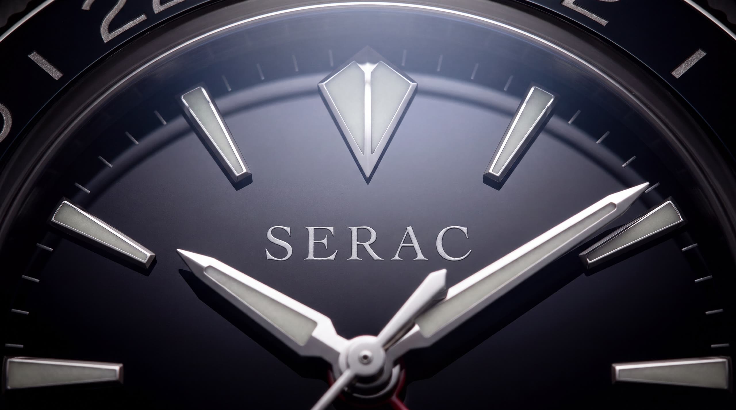 Macro of the obsidian lacquer dial: the faceted white-gold peak index above the SERAC signature, hour and minute hands in the foreground.