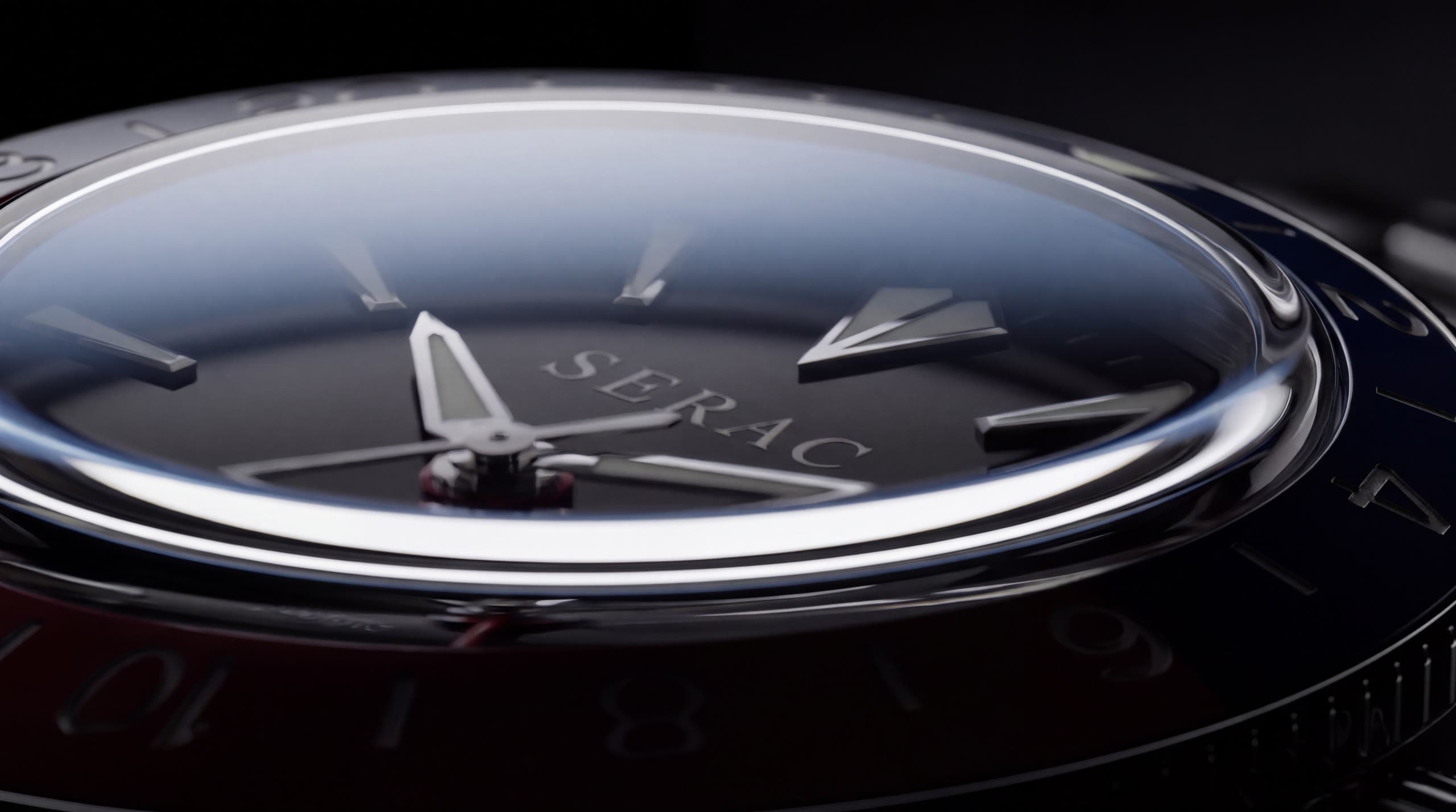 Grazing light across the flat sapphire crystal, the dial and the red and blue bezel beneath it.